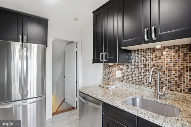 a bathroom with a granite countertop double vanity sink and mirror