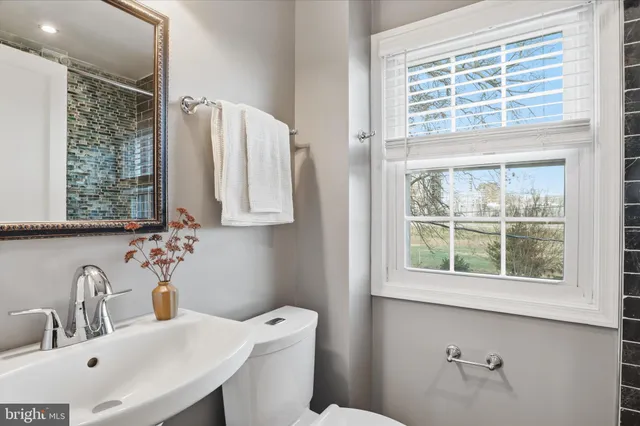 a bathroom with a sink a toilet and a window