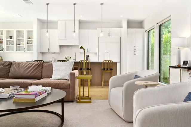 a kitchen with stainless steel appliances granite countertop a table chairs refrigerator and wooden floors