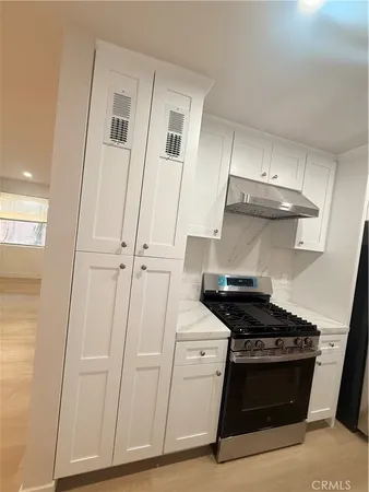 a kitchen with white cabinets and white appliances