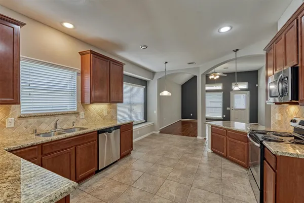 a large kitchen with kitchen island granite countertop a sink and cabinets
