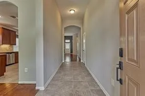 a view of a hallway with wooden floor and a living room