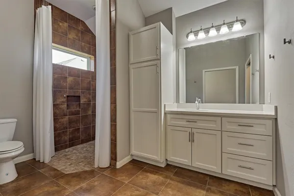a bathroom with a toilet a sink and mirror