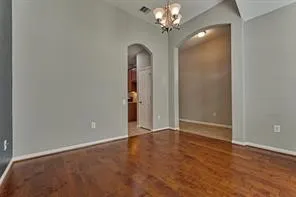 an empty room with a chandelier and a chandelier fan
