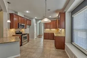 a kitchen with stainless steel appliances granite countertop a stove refrigerator and cabinets