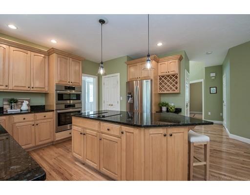 133 Green Road Bolton, MA 01740 - Photo 10 of 30 a kitchen with stainless steel appliances kitchen island granite countertop a stove a sink and a refrigerator