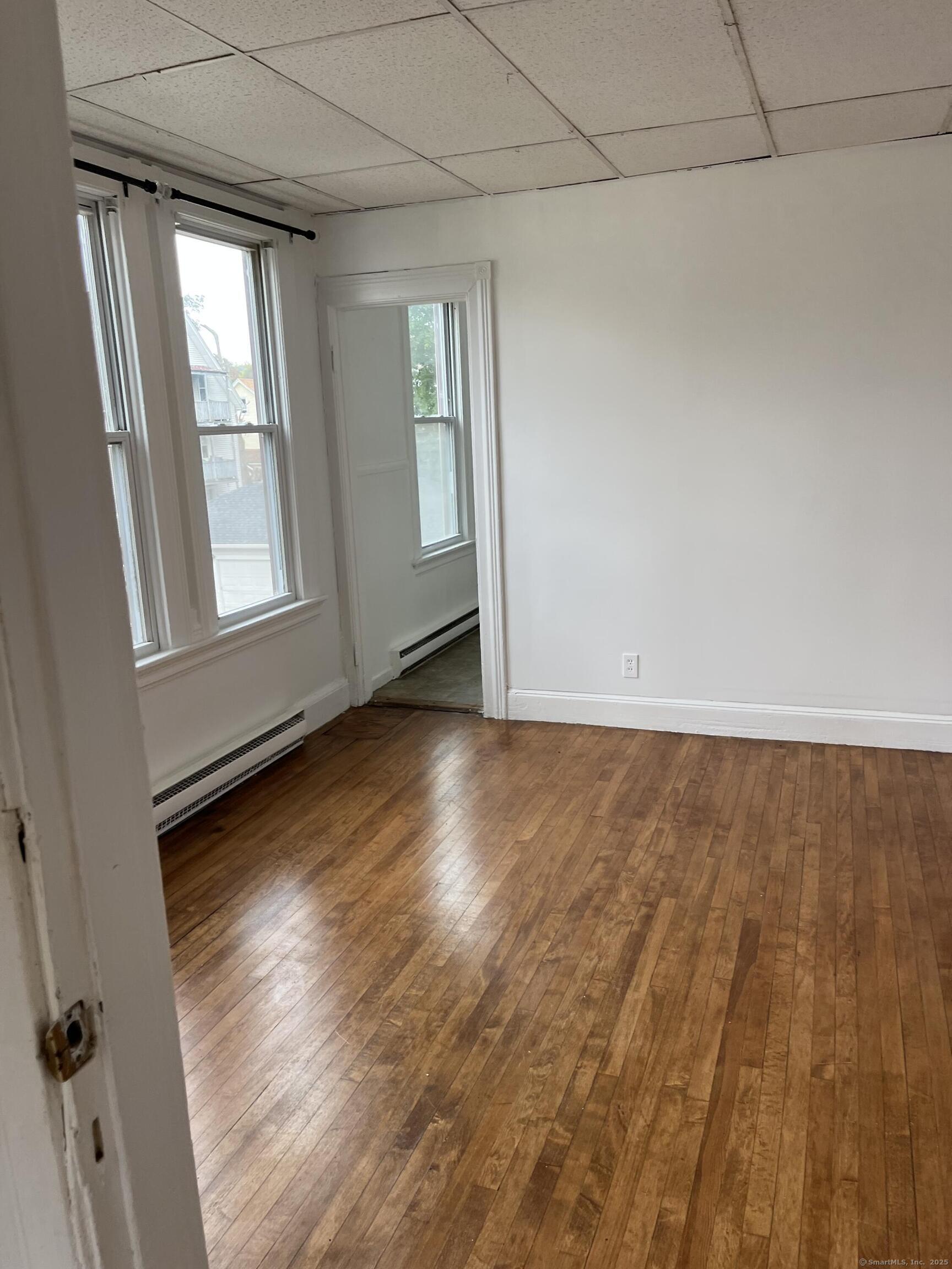 144 View Street Meriden, CT 06450 - Photo 3 of 3 an empty room with wooden floor and windows