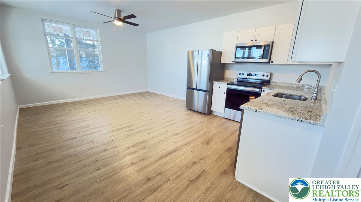 403 North Walnut Street, Unit D Bath, PA 18014 - Photo 3 of 17 a kitchen with stainless steel appliances granite countertop a refrigerator sink and stove