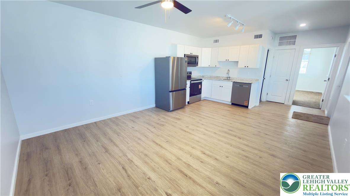 403 North Walnut Street, Unit D Bath, PA 18014 - Photo 4 of 17 a open kitchen with stainless steel appliances a refrigerator and wooden floor