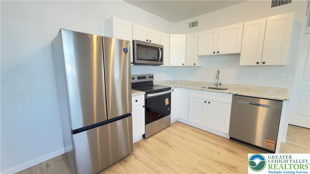 403 North Walnut Street, Unit D Bath, PA 18014 - Photo 7 of 17 a kitchen with stainless steel appliances a refrigerator sink and microwave
