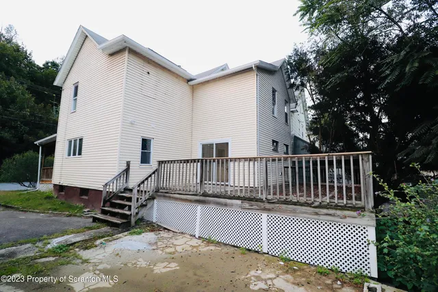 a view of backyard with deck and outdoor seating