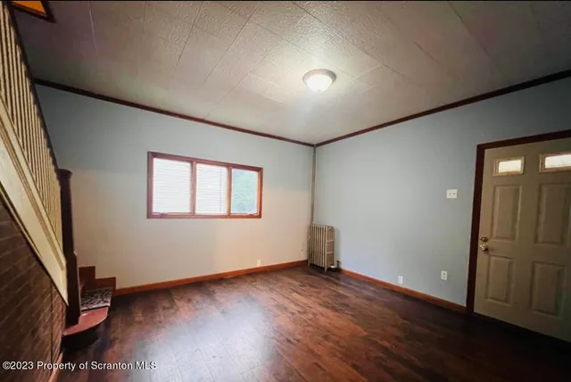 an empty room with wooden floor and a window