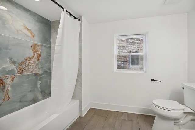 a bathroom with a toilet and shower