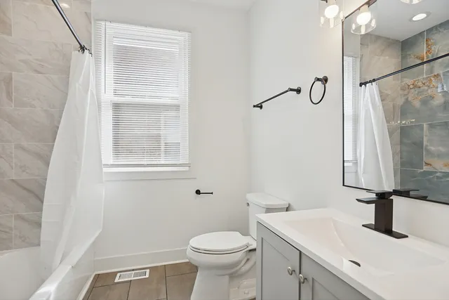 a bathroom with a sink a toilet and a mirror