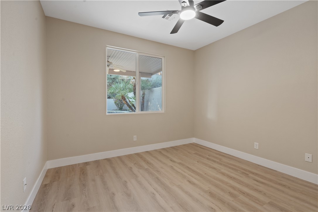 1662 Ravanusa Drive Henderson, NV 89052 - Photo 16 of 74 A well-lit bedroom features durable laminate flooring and a modern ceiling fan for comfort.