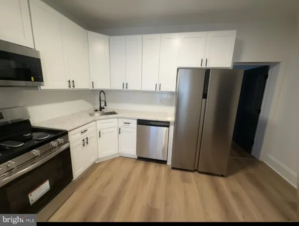 a kitchen with a sink a refrigerator and cabinets