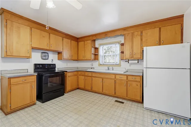 a kitchen with granite countertop a refrigerator sink stove and oven