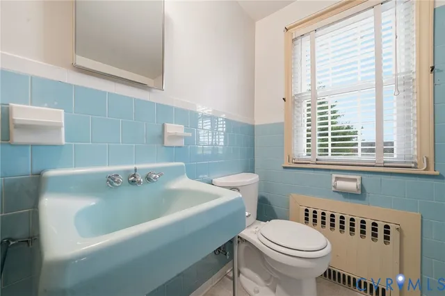 a bathroom with a sink a toilet and window