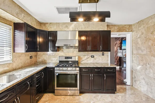 a kitchen with stainless steel appliances granite countertop a stove and a sink