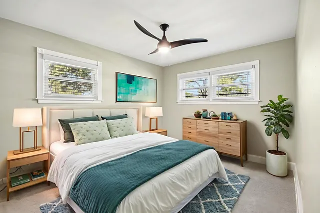 a bedroom with a large bed and a potted plant