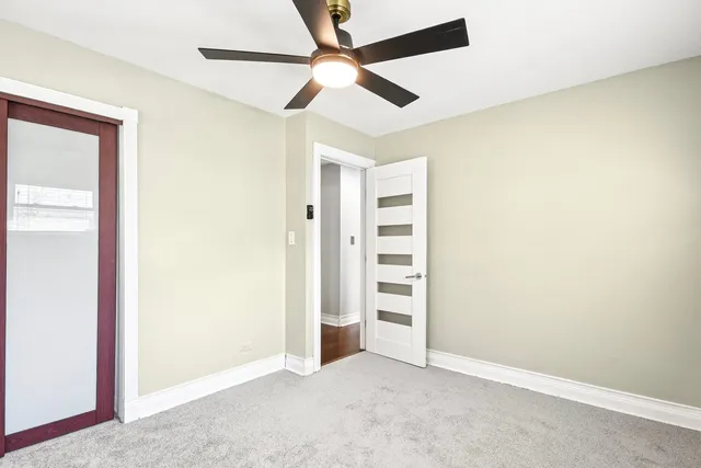 an empty room with closet and fan