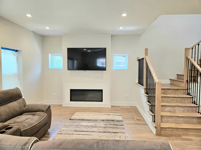 a living room with furniture a flat screen tv and a fireplace