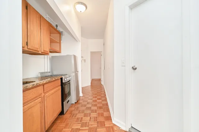 a hallway with stove top oven and cabinets