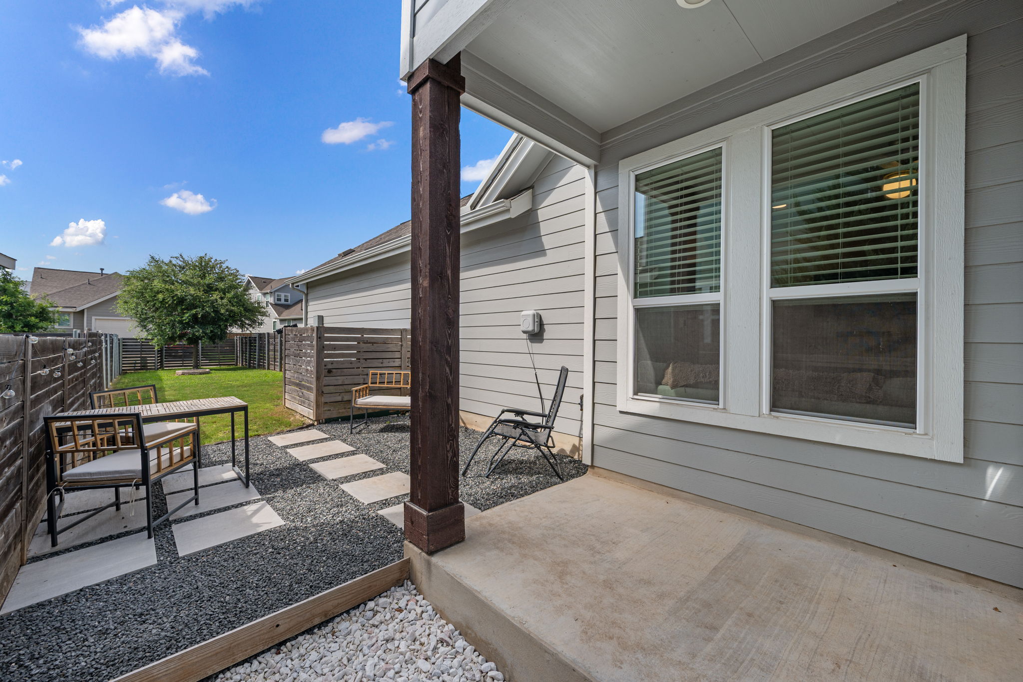 5409 Fox Wing Way Austin, TX 78747 - Photo 20 of 26 A private backyard oasis features a covered patio with an inviting gravel and paver pathway leading to a green lawn.