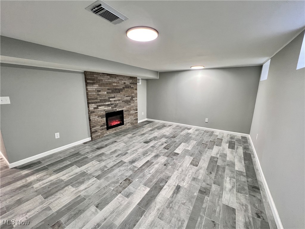 2191 Brockway Road Cleveland, OH 44118 - Photo 19 of 26 Basement with a large fireplace and ceremic / wood-style floors