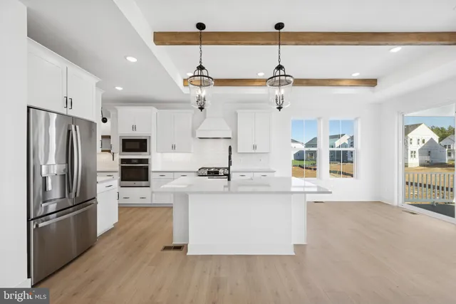 a kitchen with stainless steel appliances a stove a sink and a refrigerator