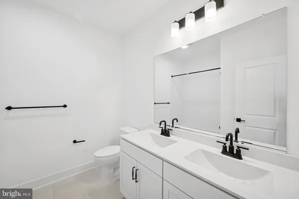 a bathroom with a sink a toilet and a large mirror