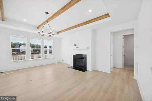 a view of an empty room with a fireplace and a window