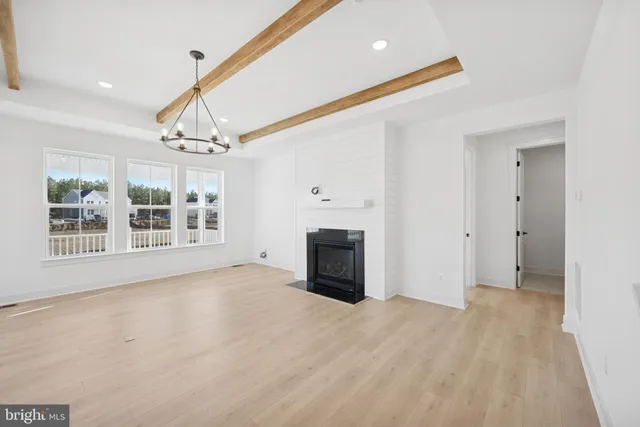 a view of an empty room with a fireplace and a window