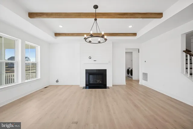 a view of an empty room with a window and a fireplace