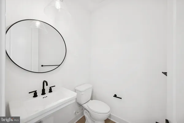 a bathroom with a toilet a sink and mirror