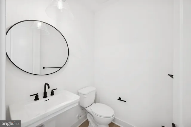 a bathroom with a toilet a sink and mirror