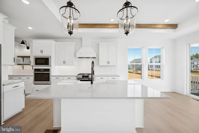 a kitchen with stainless steel appliances granite countertop a sink dishwasher and a stove with wooden floor