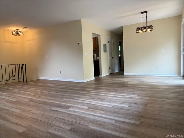 a view of a livingroom with wooden floor and a ceiling fan
