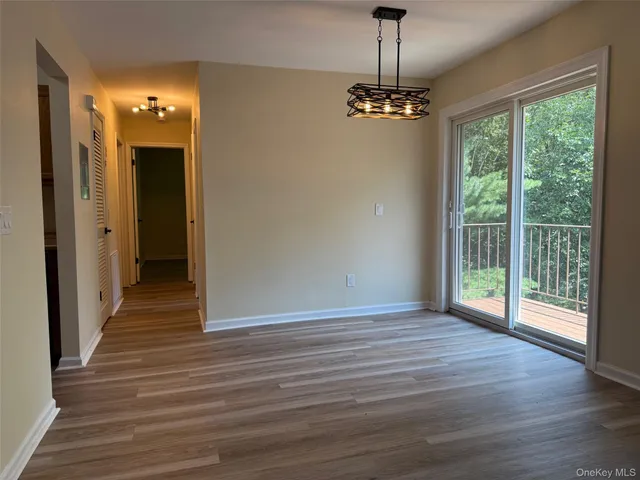 a view of a livingroom with wooden floor staircase and a chandelier