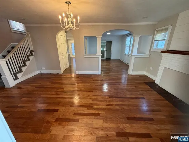 an empty room with wooden floor and stairs