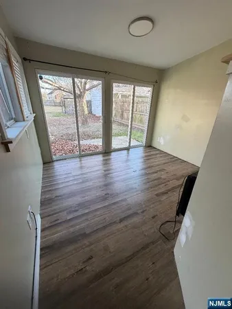 a kitchen with stainless steel appliances a sink dishwasher a stove and white cabinets with wooden floor