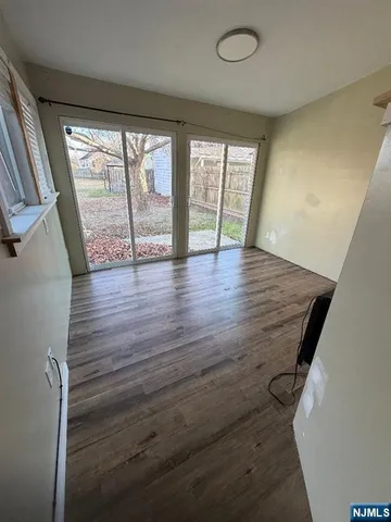 a kitchen with stainless steel appliances a sink dishwasher a stove and white cabinets with wooden floor