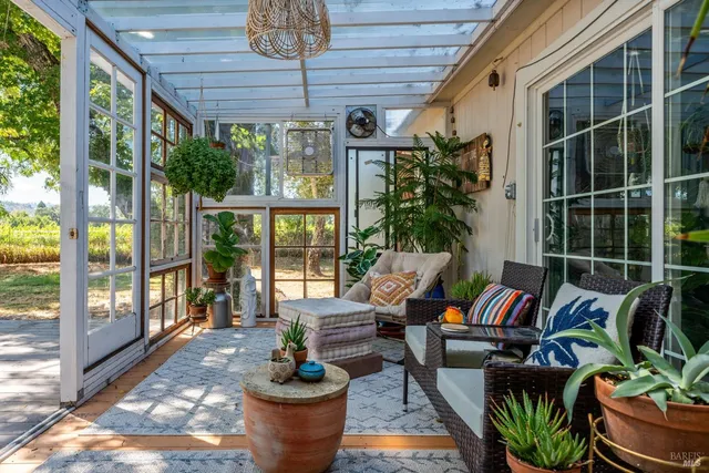 a living room with patio furniture and a potted plant