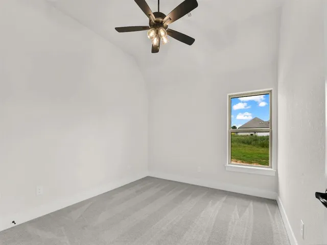 an empty room with a window and a fan