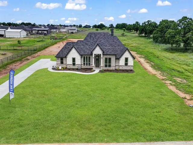 an aerial view of a house with swimming pool big yard and a large tree