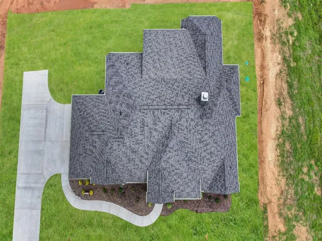 an aerial view of a house with a yard