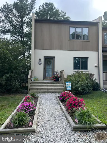 a front view of a house with a big yard and potted plants