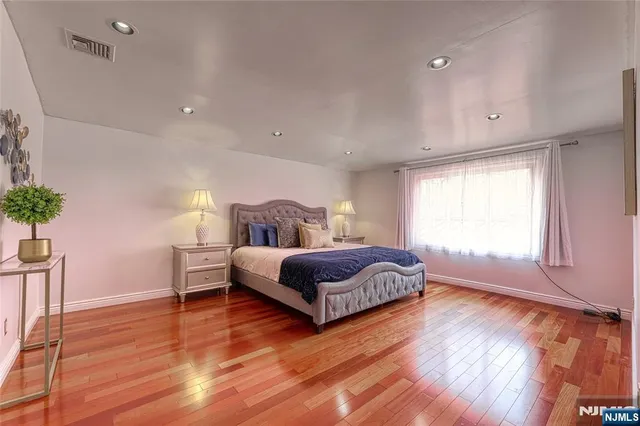 a kitchen with stainless steel appliances granite countertop a refrigerator a sink dishwasher a stove and white countertops with wooden floor