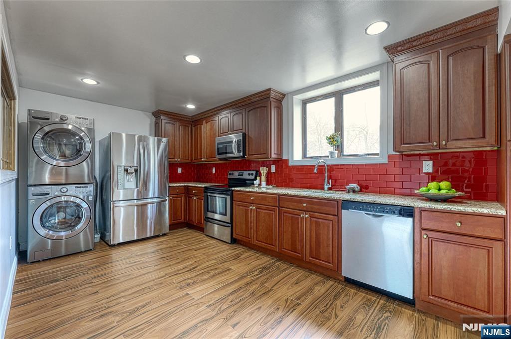91 Chestnut Ridge Road Saddle River, NJ 07458 - Photo 39 of 41 a kitchen with stainless steel appliances granite countertop a refrigerator a sink dishwasher a stove and white countertops with wooden floor