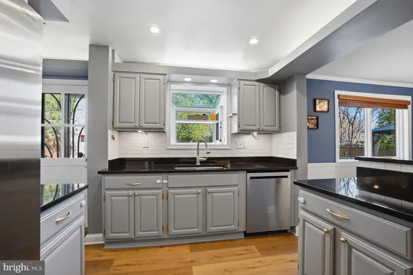 a kitchen with stainless steel appliances and wooden floor
